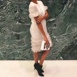 White dress with ruffle details on arms and hem